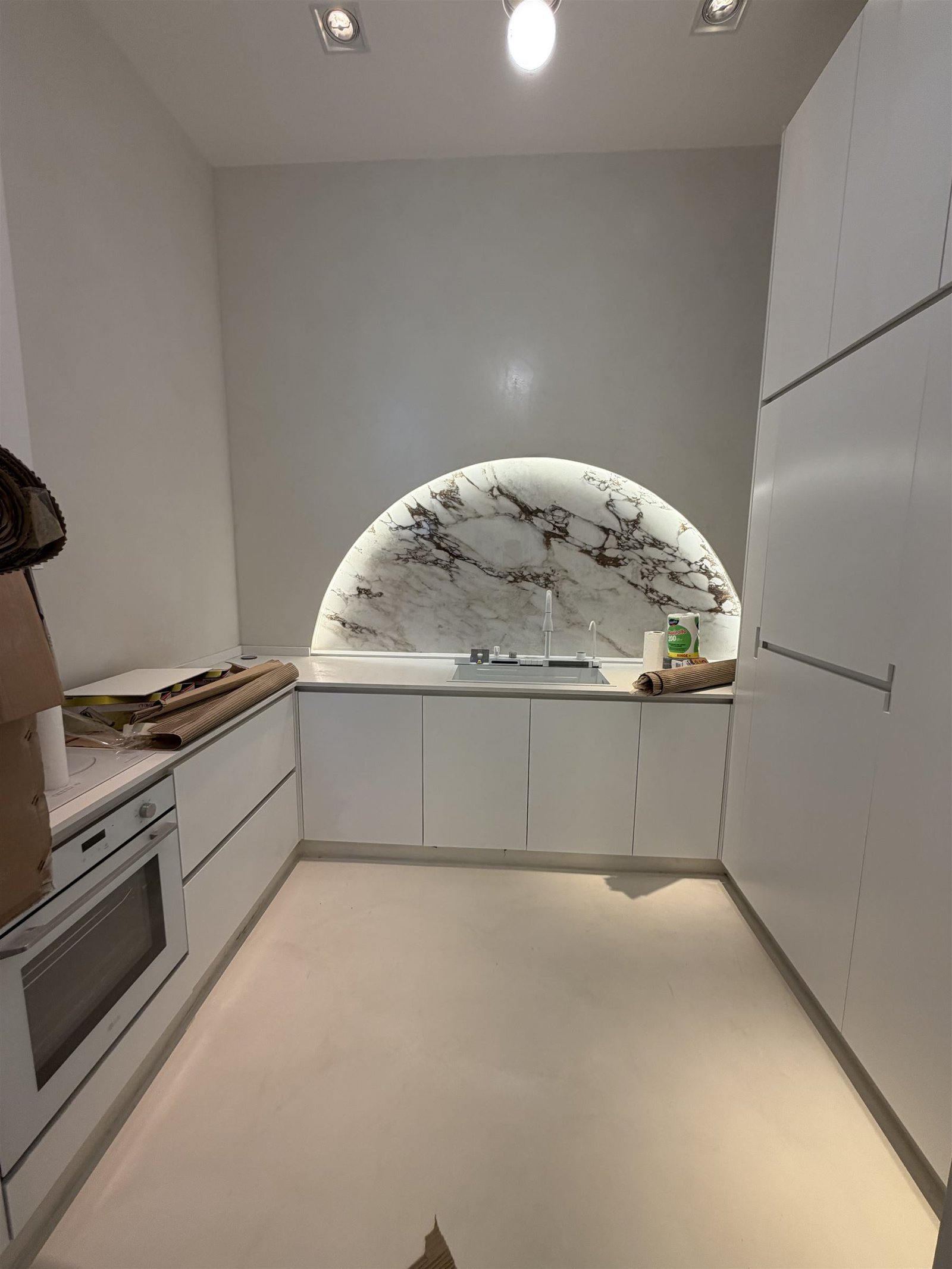 Cocina con nicho de mármol iluminado sobre la mesada