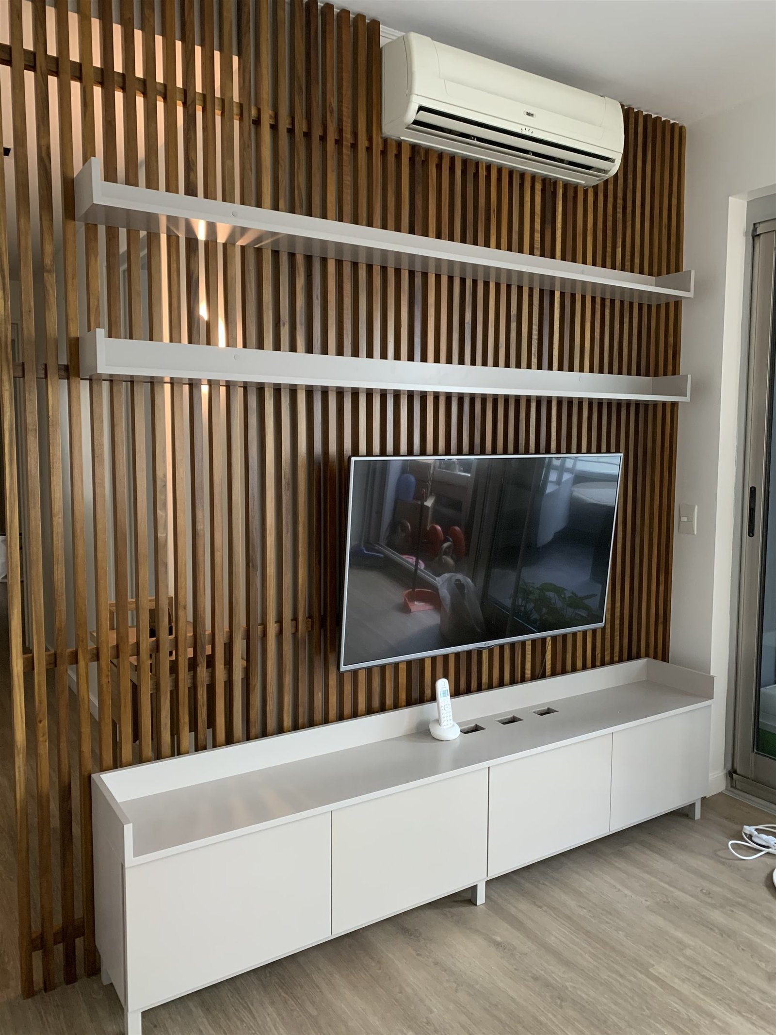 Panel de TV con listones de madera y estantes flotantes